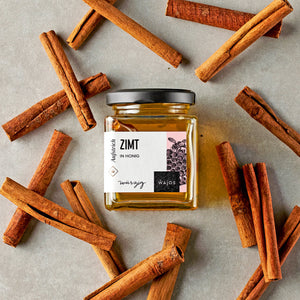 Zimt in Honig dargestellt mit Zimtstangen