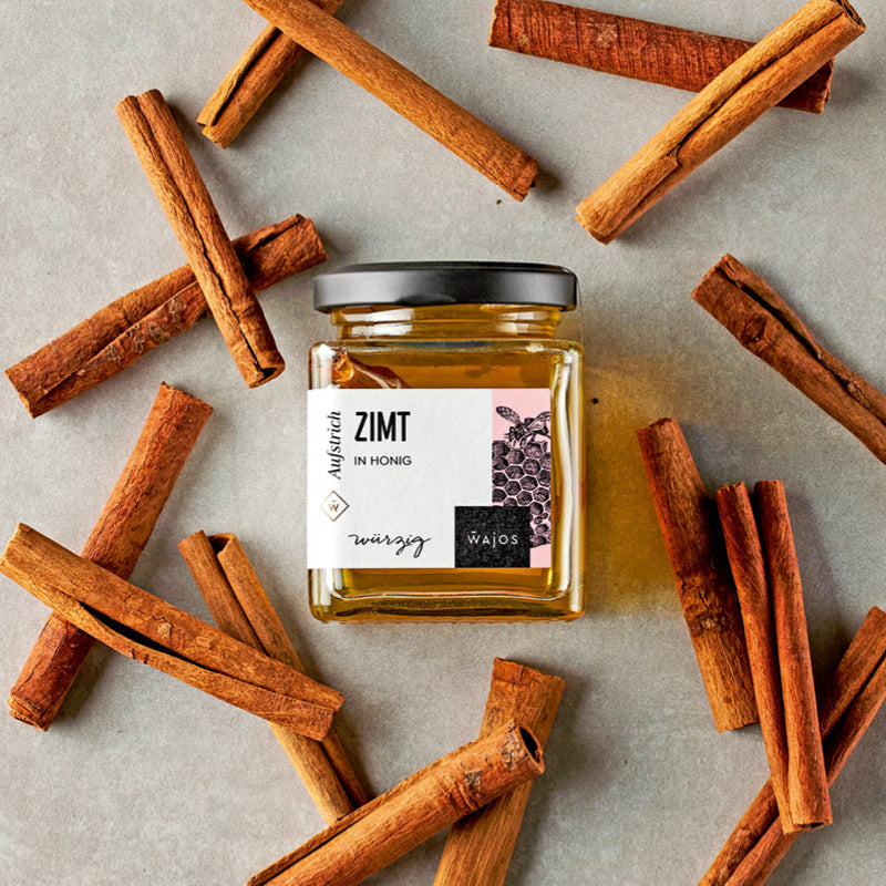Zimt in Honig dargestellt mit Zimtstangen