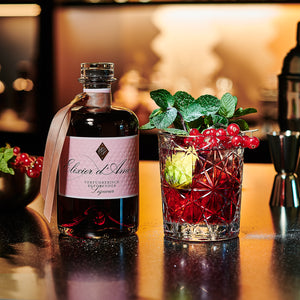 Elixier d'Amour Liqueuer dargestellt mit Cocktail und Früchten