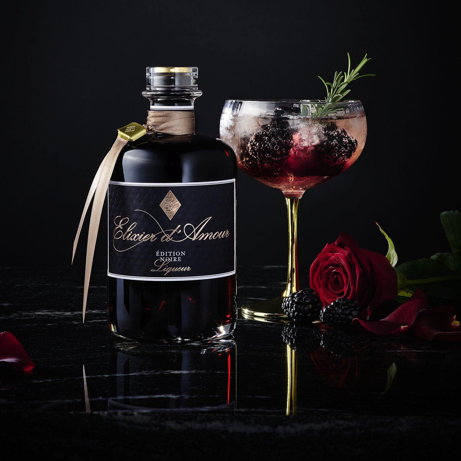 Elixier d'Amour Edition Noire dargestellt mit Cocktail