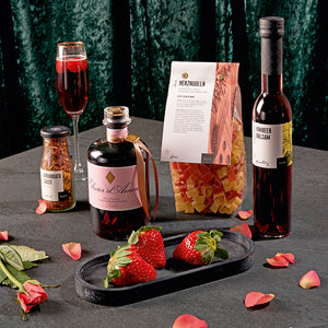 Valentinstags-Menü - Set mit Likör, Essigspezialität, Pastasauce und Herznudeln, dargestellt mit Erdbeeren und Sektglas